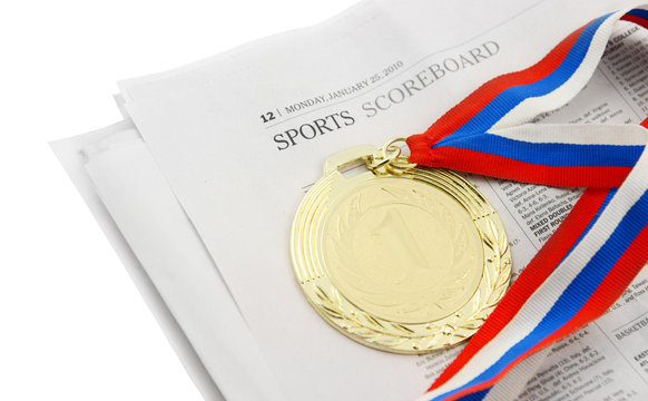 Gold medal on sport newspaper isolated on white
