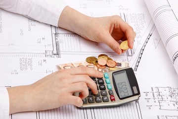 hands with house construction plan, calculator, money, coins