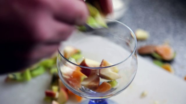 Man preparing - at home -fresh fruit salad with  joghurt.