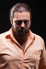 Portrait of a young serious man with long strong hair