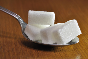 Morceaux de sucre dans une cuillère.