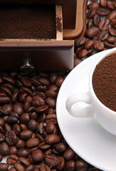 Fragment of a cup with ground coffee and coffee beens