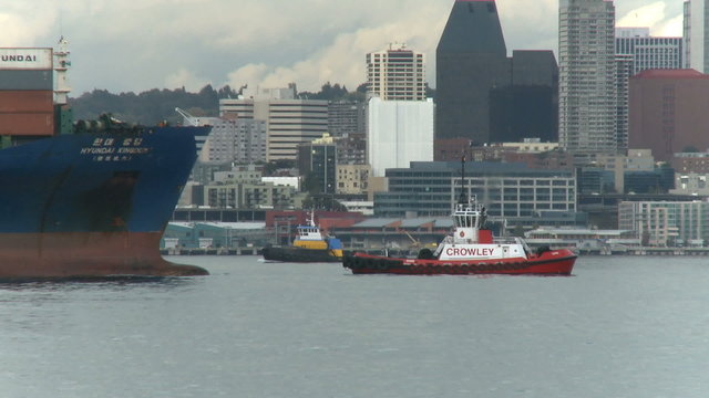 Cargo ship being guided by tug boat near seattle