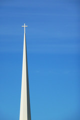 Obraz premium White church spire against a blue sky