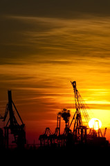 Obraz na płótnie Canvas Sunset over industrial harbor