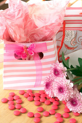 Two gift bags with pink candy around