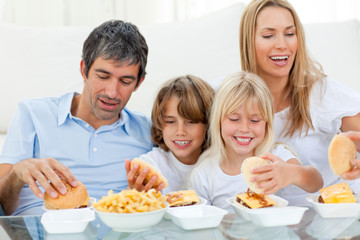 Obraz na płótnie Canvas Loving family eating hamburgers
