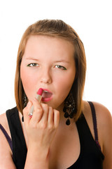 Pretty teenage girl applying lipstick