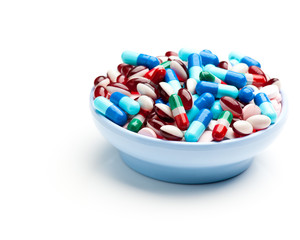Bowl of multicolored pills, tablets, and capsules