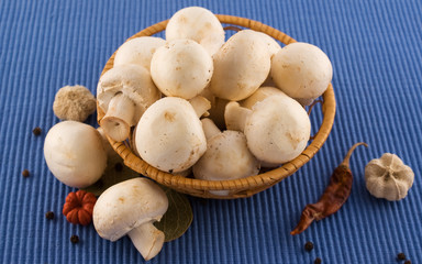 Mushrooms in the basket with pepper and herbs