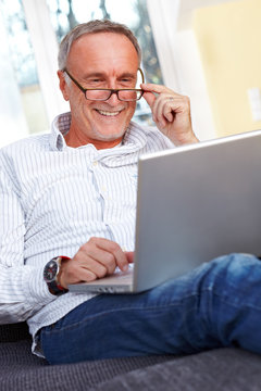 Mature man with laptop and reading specs