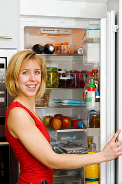 Junge Frau am K&uuml;hlschrank