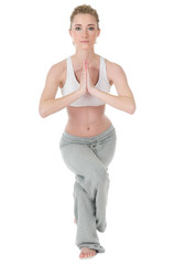 Young woman doing yoga, eagle / garudasana position