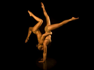 Two acrobatic girl toned in gold
