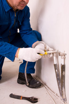 Plumber fixing water pipe