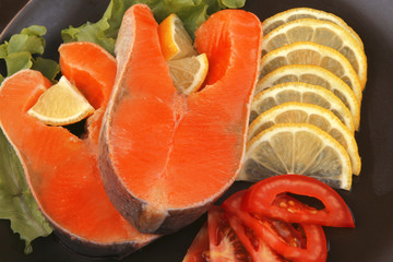 two salmon steak on dark dish