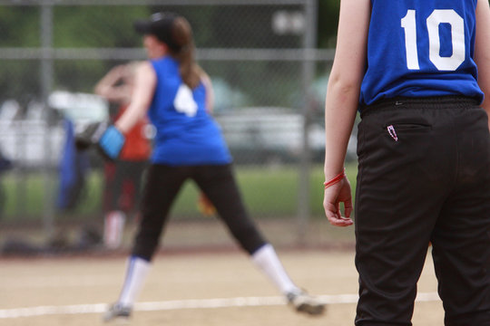 first basemen getting ready as the pitcher throws the ball