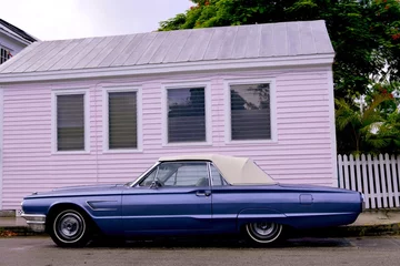  Blauwe converteerbare Thunderbird-auto over roze houten huis © lunamarina