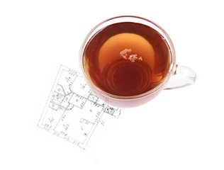 Glass cup of tea on house plan isolated