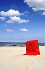 Naklejka premium Roter Strandkorb am Meer Hochformat