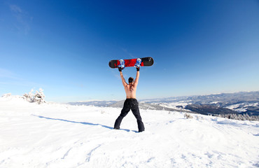 Snowboarder topless standing on the mountain