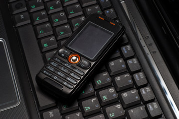 Obraz premium Mobile phone on a laptop