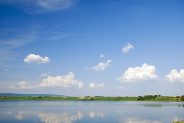 beautiful landscape with sky and clouds reflected into lake