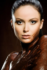 Sexy woman with body covered of sweet cream chocolate