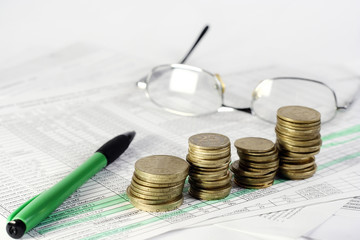 pen, glasses and coins on document