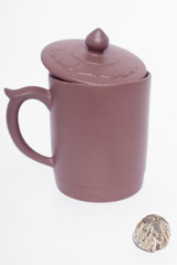 green tea ball with out of focus clay cup with lid