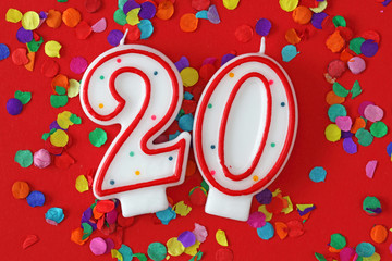 Number twenty birthday candle on red background