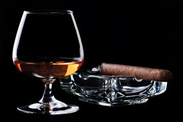 Snifter glass of cognac and cigar