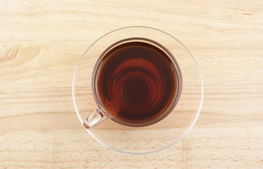 Glass cup of tea on wooden background