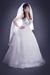 studio portrait of a happy bride on a dark gray background