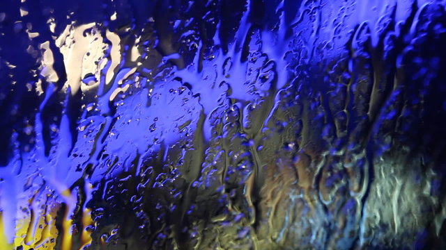 Wassertropfen auf Scheibe, blaues Licht