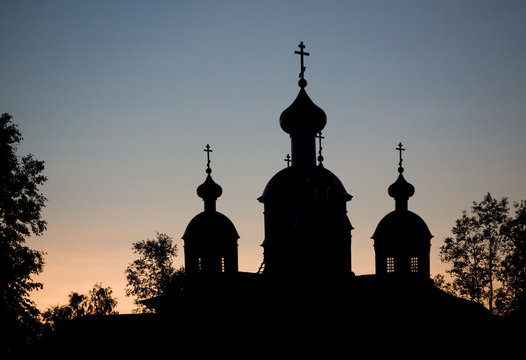 Christian church silhouette on sunset sky background