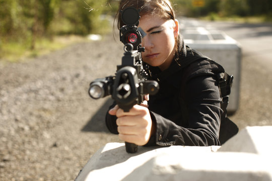 Woman aiming rifle