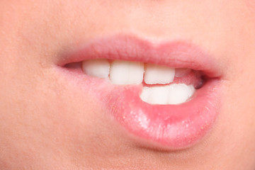 Closeup of woman chewing lips