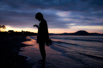 Silhouette of a woman at dramatic sunset at the beach