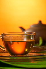 Cup with greean tea and clay teapot