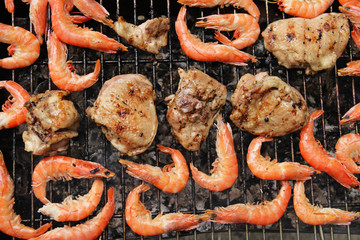 Shrimps and pork are fried on a brazier