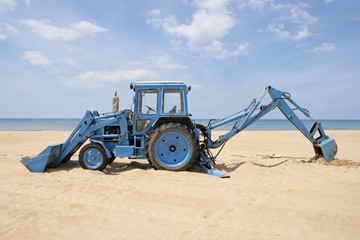 Tractor on a beach against the sea