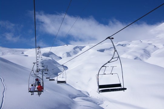 View on winter mountain slopes and ski bench lift