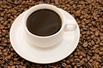 White coffee cup filled with coffee beans