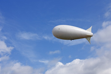 Fototapeta na wymiar White balloon against the blue sky and clouds