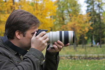 The man with the camera photographs an autumn landscape