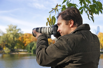 The man with the camera photographs an autumn landscape