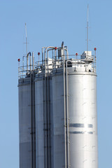 Tall metal silos for storing grain against a blue sky