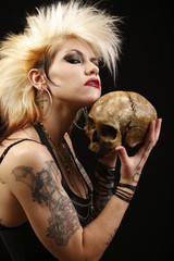 A sexy punk rocker woman holding a human skull