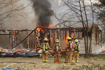 Fototapeta premium Firemen at burning house.